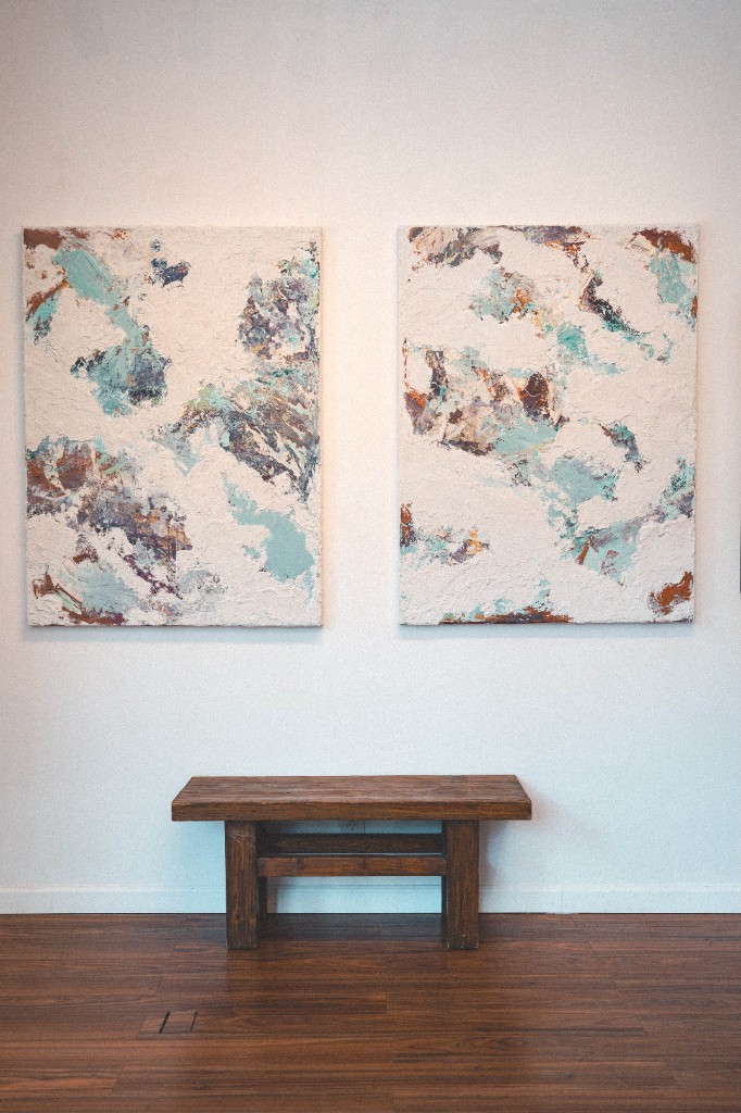 Gallery interior with abstract paintings and bench at Presley Fine Arts